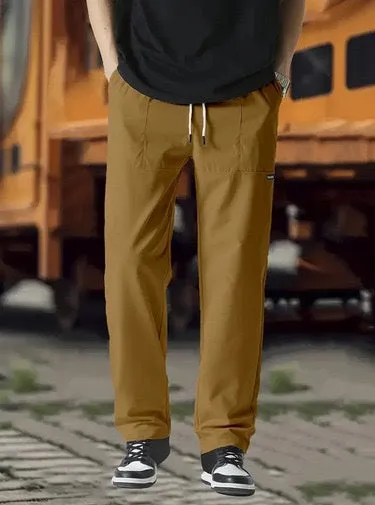 Men's light grey polyester trousers for spring and autumn wear, laid flat.