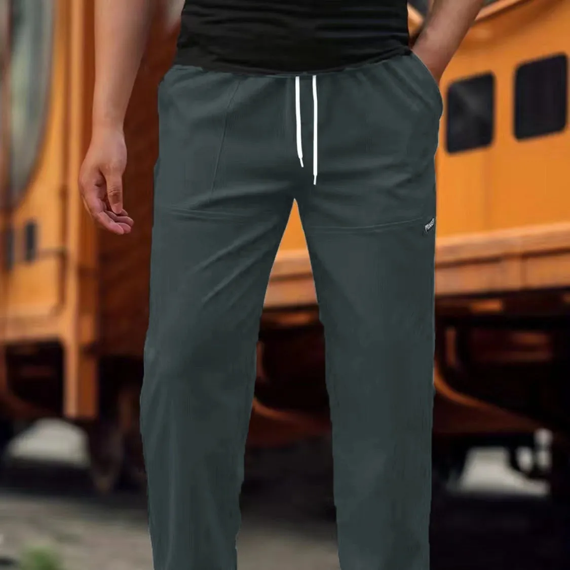 Men's light grey polyester trousers for spring and autumn wear, laid flat.