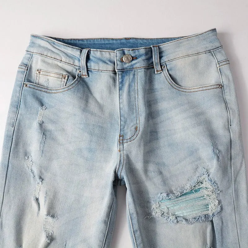 Men's light blue distressed slim fit jeans with five pocket patchwork, enzyme washed, side view