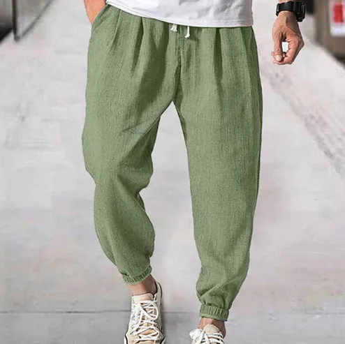 Man wearing loose light-coloured cotton trousers with elasticated ankle cuffs, showing front and side views.