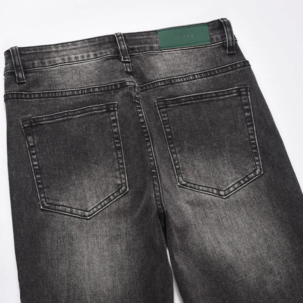 Men's black washed denim jeans on a flat surface showing full leg and pocket details