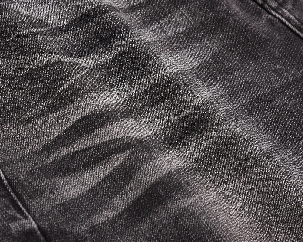Men's black washed denim jeans on a flat surface showing full leg and pocket details