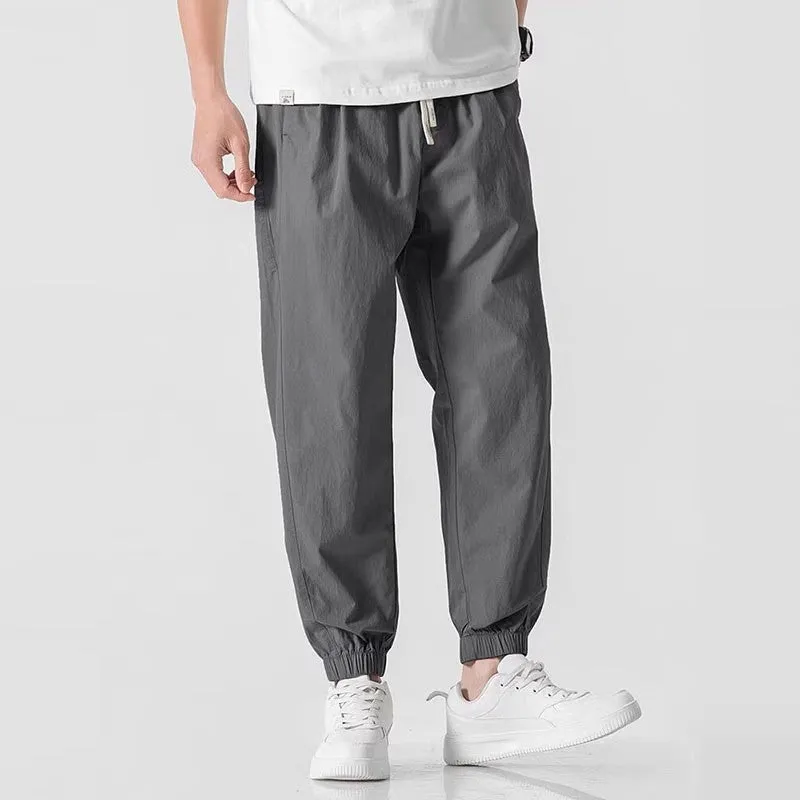 Men's loose cuffed cargo pants in black polyester fabric with cuffed hem and relaxed fit