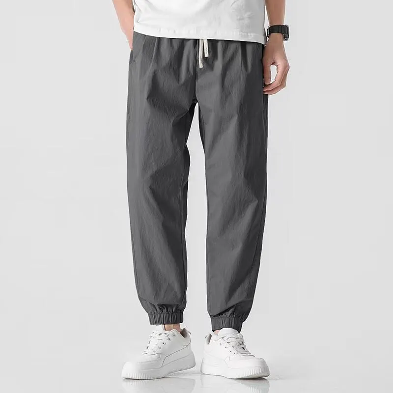 Men's loose cuffed cargo pants in black polyester fabric with cuffed hem and relaxed fit