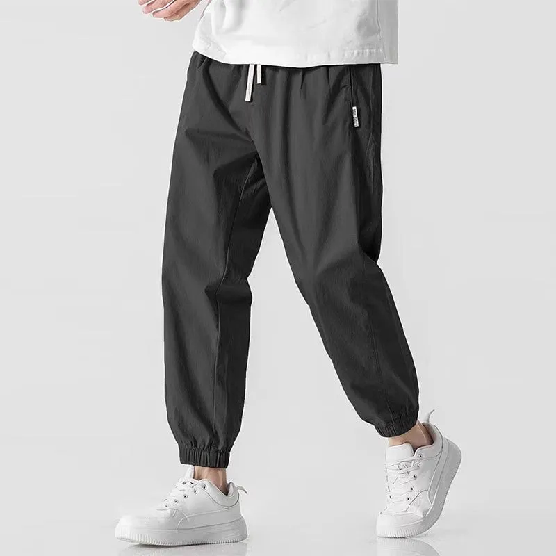 Men's loose cuffed cargo pants in black polyester fabric with cuffed hem and relaxed fit
