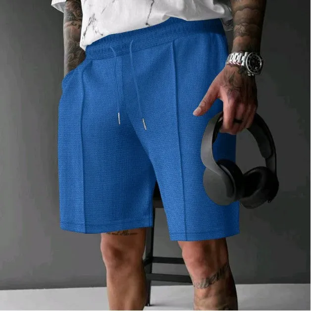 Solid colour five-point polyester sports shorts in khaki with elastic waistband, side view on model