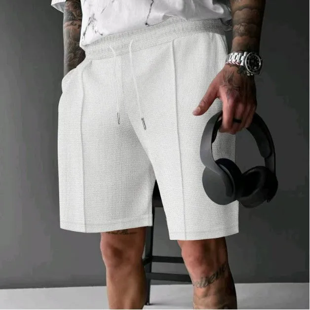 Solid colour five-point polyester sports shorts in khaki with elastic waistband, side view on model