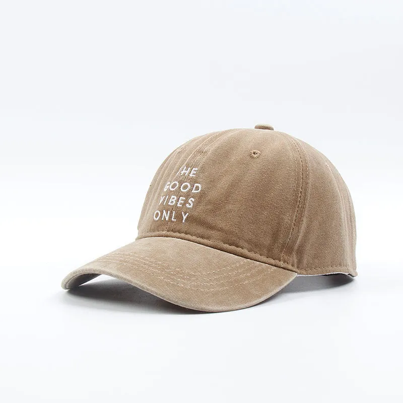 Washed cotton dad hat in bone colour with embroidered THE GOOD VIBES ONLY lettering, adjustable snapback, short curling brim
