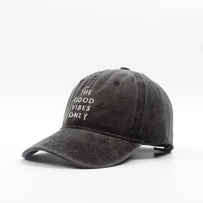 Washed cotton dad hat in bone colour with embroidered THE GOOD VIBES ONLY lettering, adjustable snapback, short curling brim