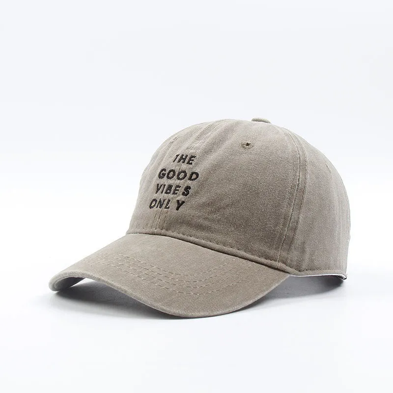 Washed cotton dad hat in bone colour with embroidered THE GOOD VIBES ONLY lettering, adjustable snapback, short curling brim