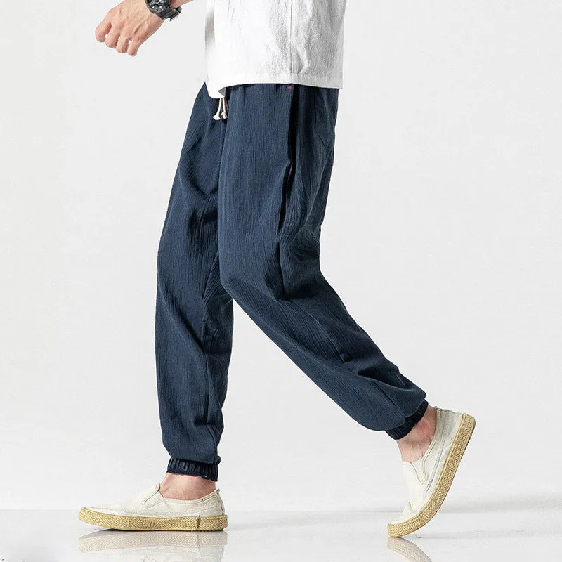 Men's cotton linen harem trousers in beige, shown with elastic waistband and tapered legs, available in multiple sizes and colours