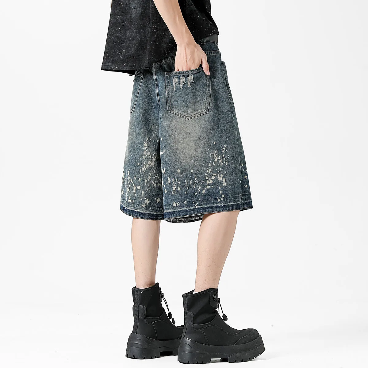 Retro blue washed denim shorts for men with a splash ink pattern and ripped detailing on the legs.