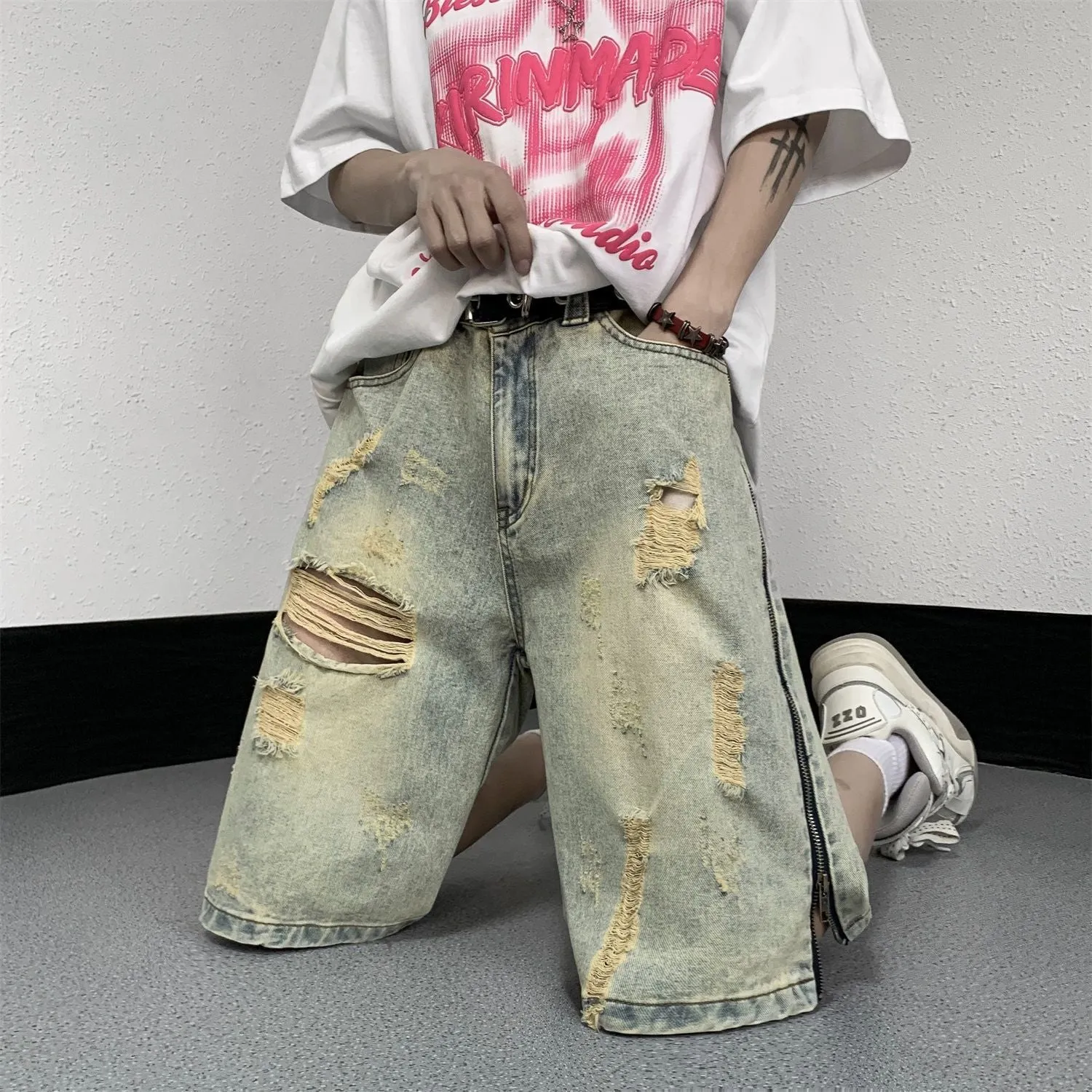 Man wearing blue loose-fit retro denim shorts with a button fly and straight leg opening.