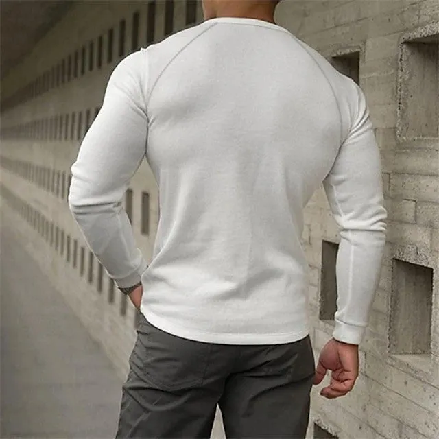 Man wearing a navy blue long-sleeved T-shirt with a Henry collar, made from cotton blend fabric.