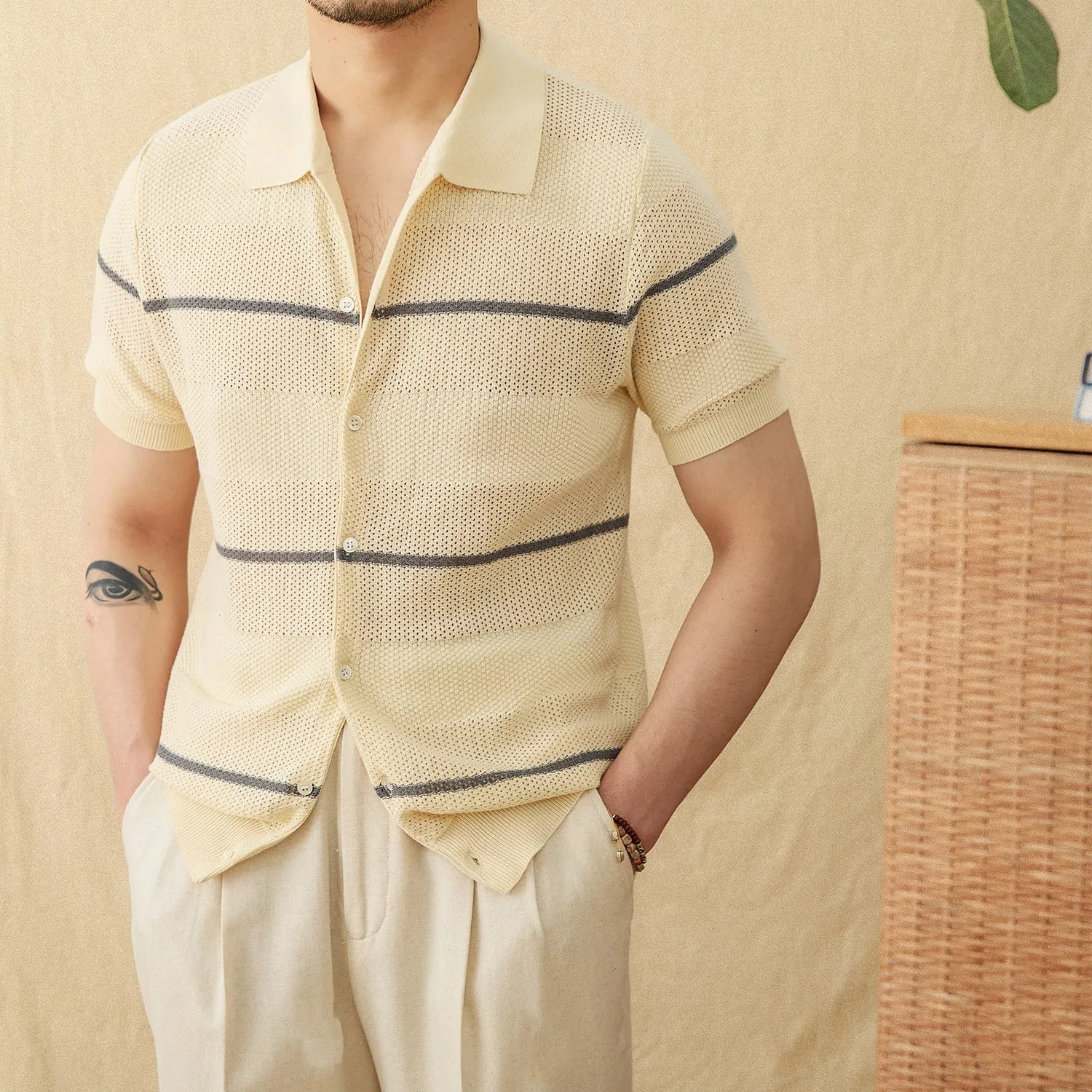 Men's camel coloured short sleeve knitted cardigan with a lapel collar on a hanger.