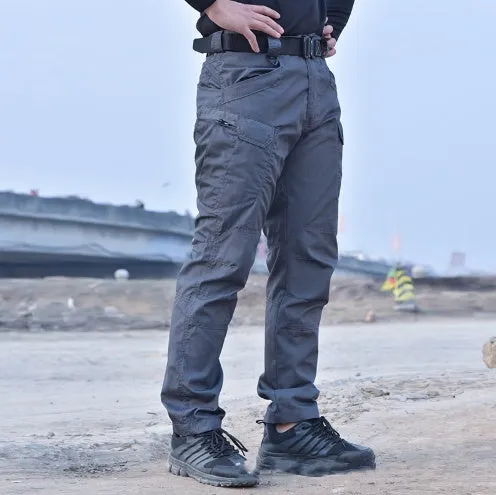 Outdoor multi-legged tactical pants in khaki cotton blend with multiple pockets on legs, shown against natural background
