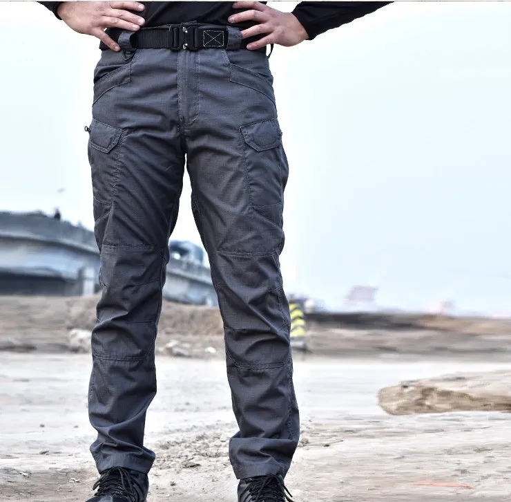 Outdoor multi-legged tactical pants in khaki cotton blend with multiple pockets on legs, shown against natural background