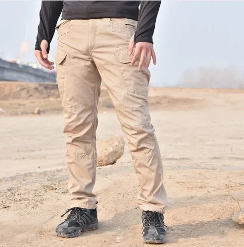 Outdoor multi-legged tactical pants in khaki cotton blend with multiple pockets on legs, shown against natural background