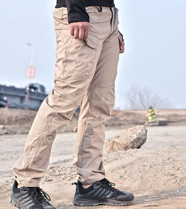 Outdoor multi-legged tactical pants in khaki cotton blend with multiple pockets on legs, shown against natural background