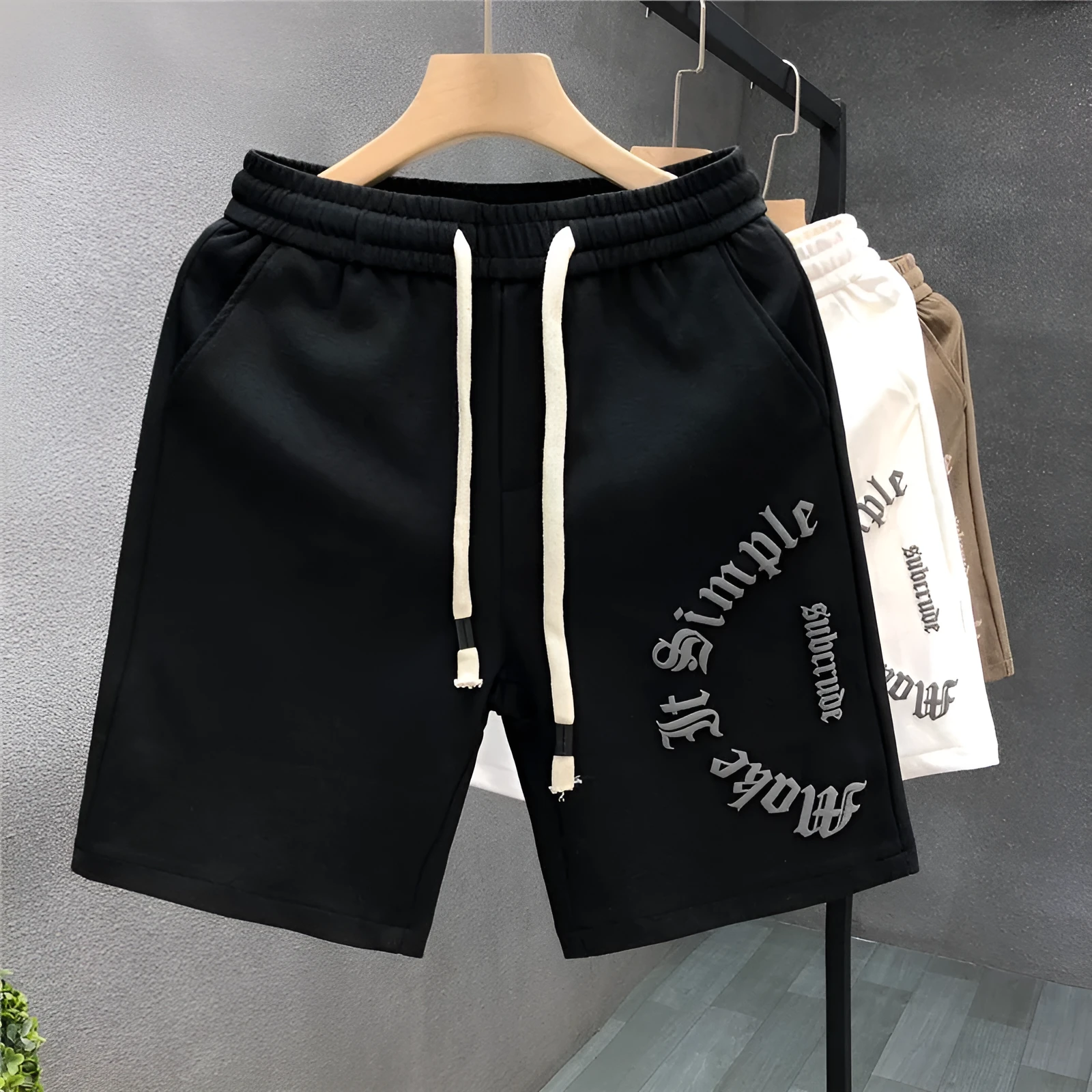 Printed cropped polyester sports pants in black for teenage men, side view showing cropped leg length