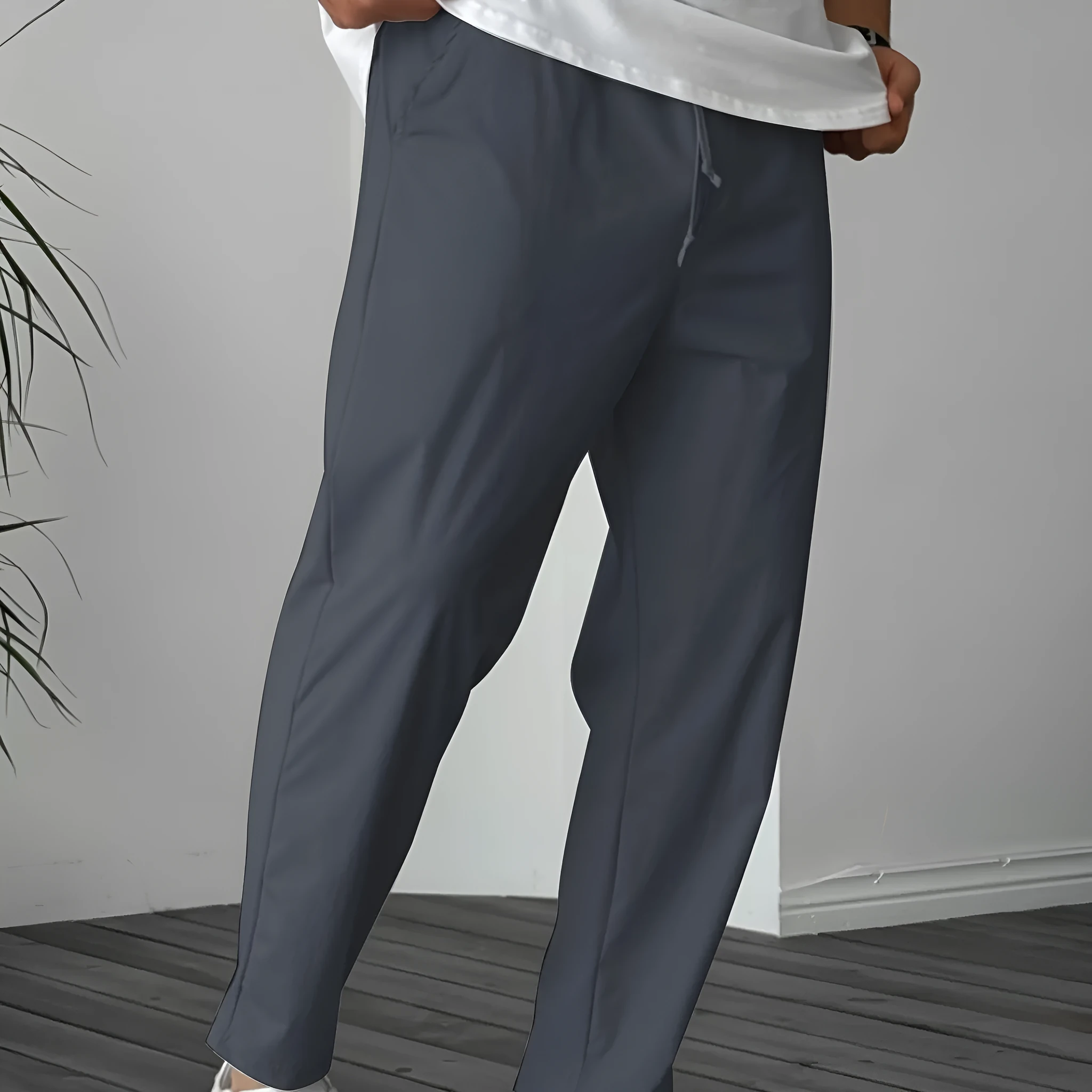 Man wearing khaki straight-leg drawstring trousers with a tonal ribbon pocket detail.