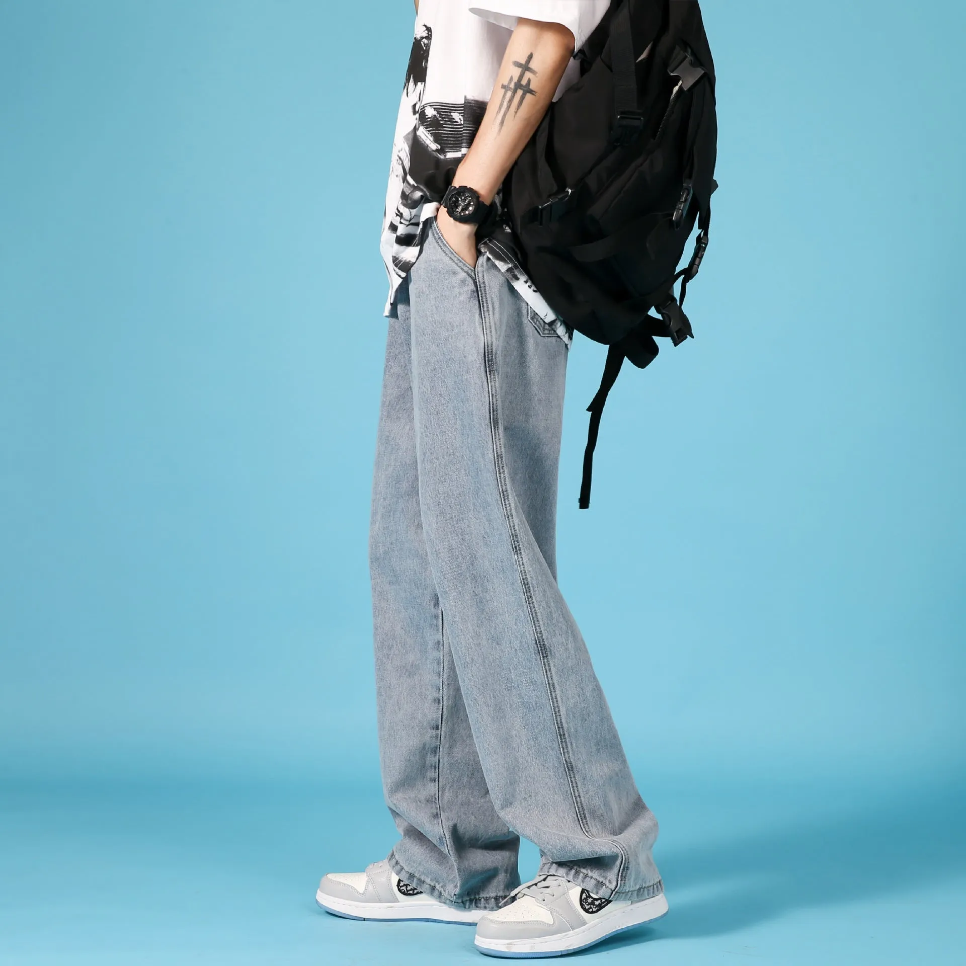 Men's straight loose denim jeans in light blue with zipper front and mid-waist fit