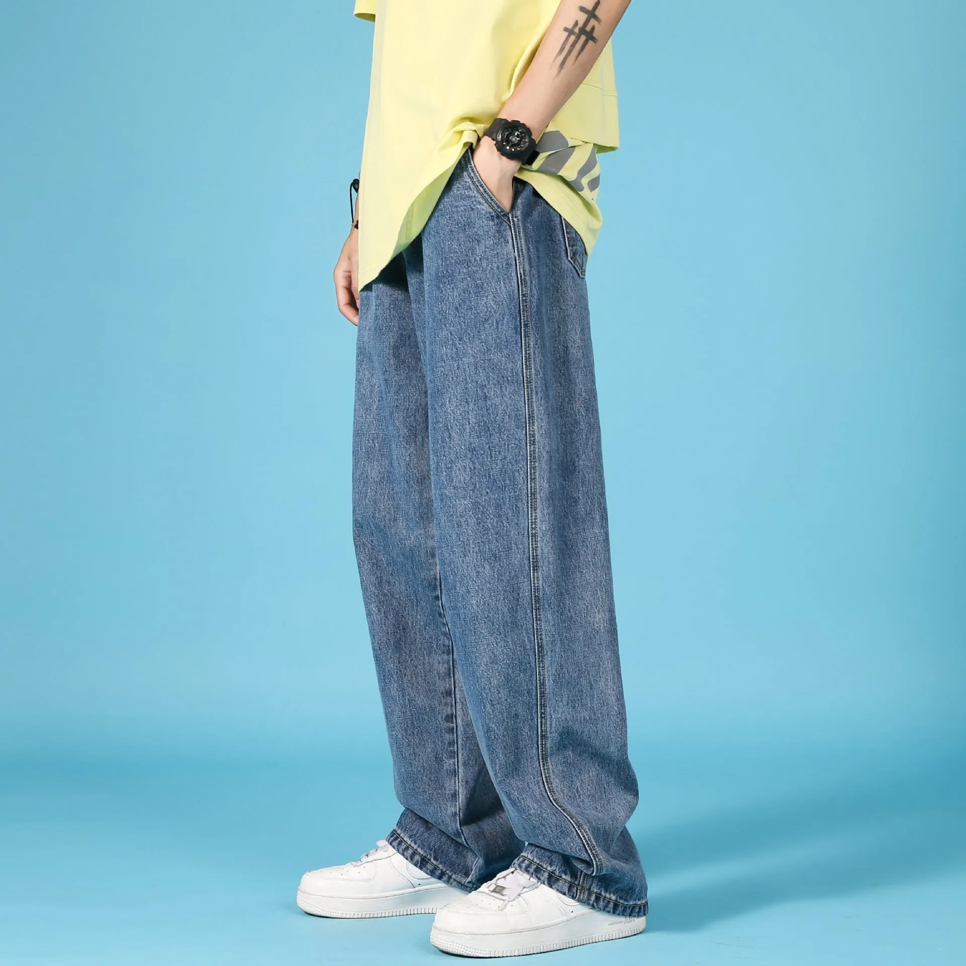 Men's straight loose denim jeans in light blue with zipper front and mid-waist fit