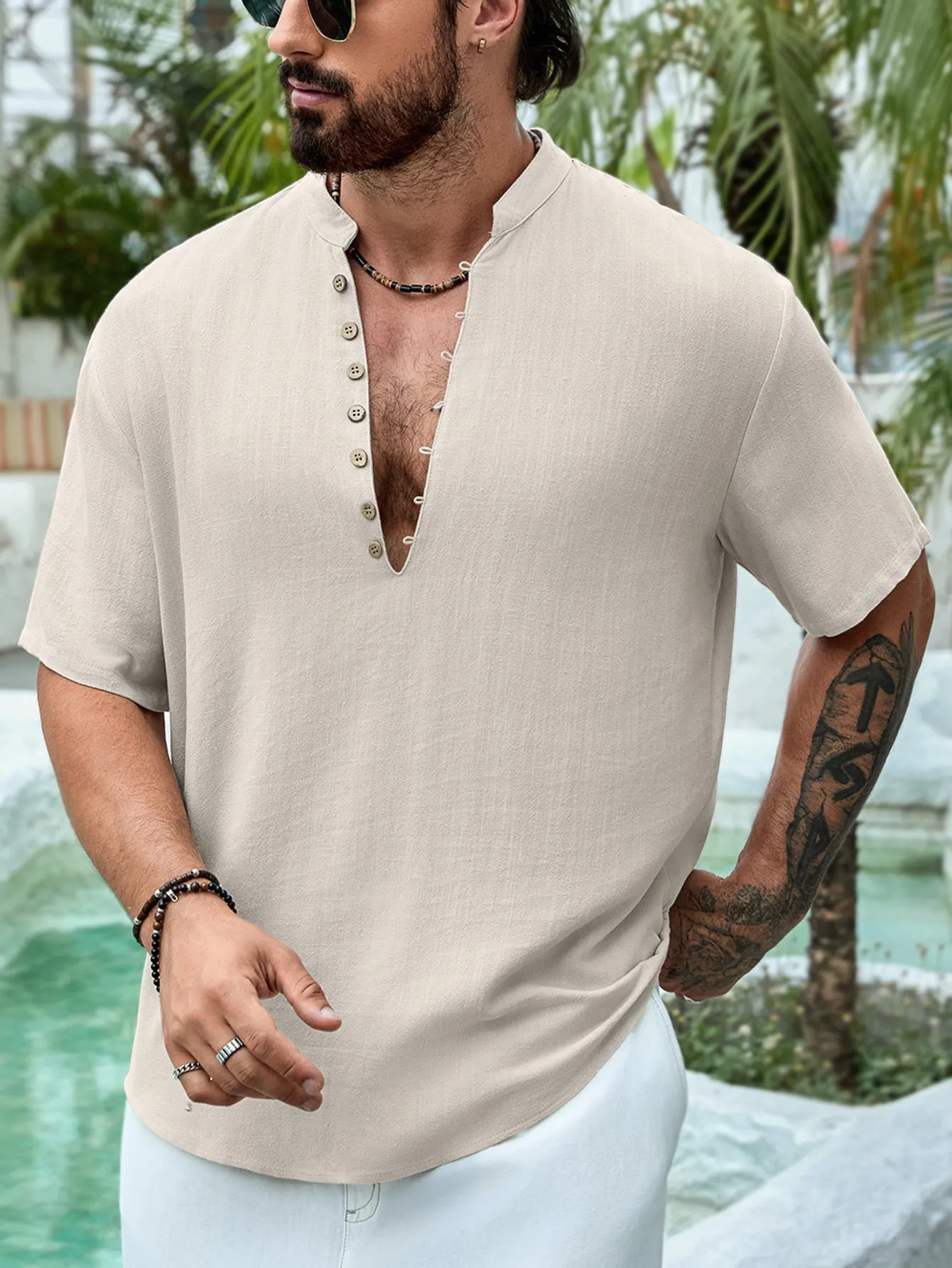 Man wearing a deep V-neck multi-button short sleeve casual shirt in a solid colour.