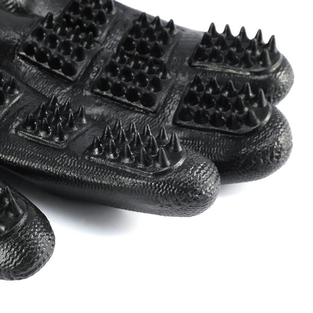 Pet hair grooming glove in black rubber with adjustable wrist strap on a light background