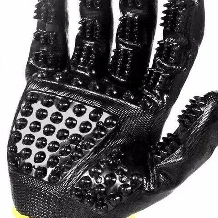Pet hair grooming glove in black rubber with adjustable wrist strap on a light background