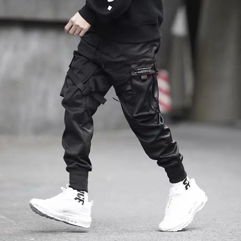 Men's black cotton harem joggers with side pockets and elastic waist, shown with drawstring and Velcro closures