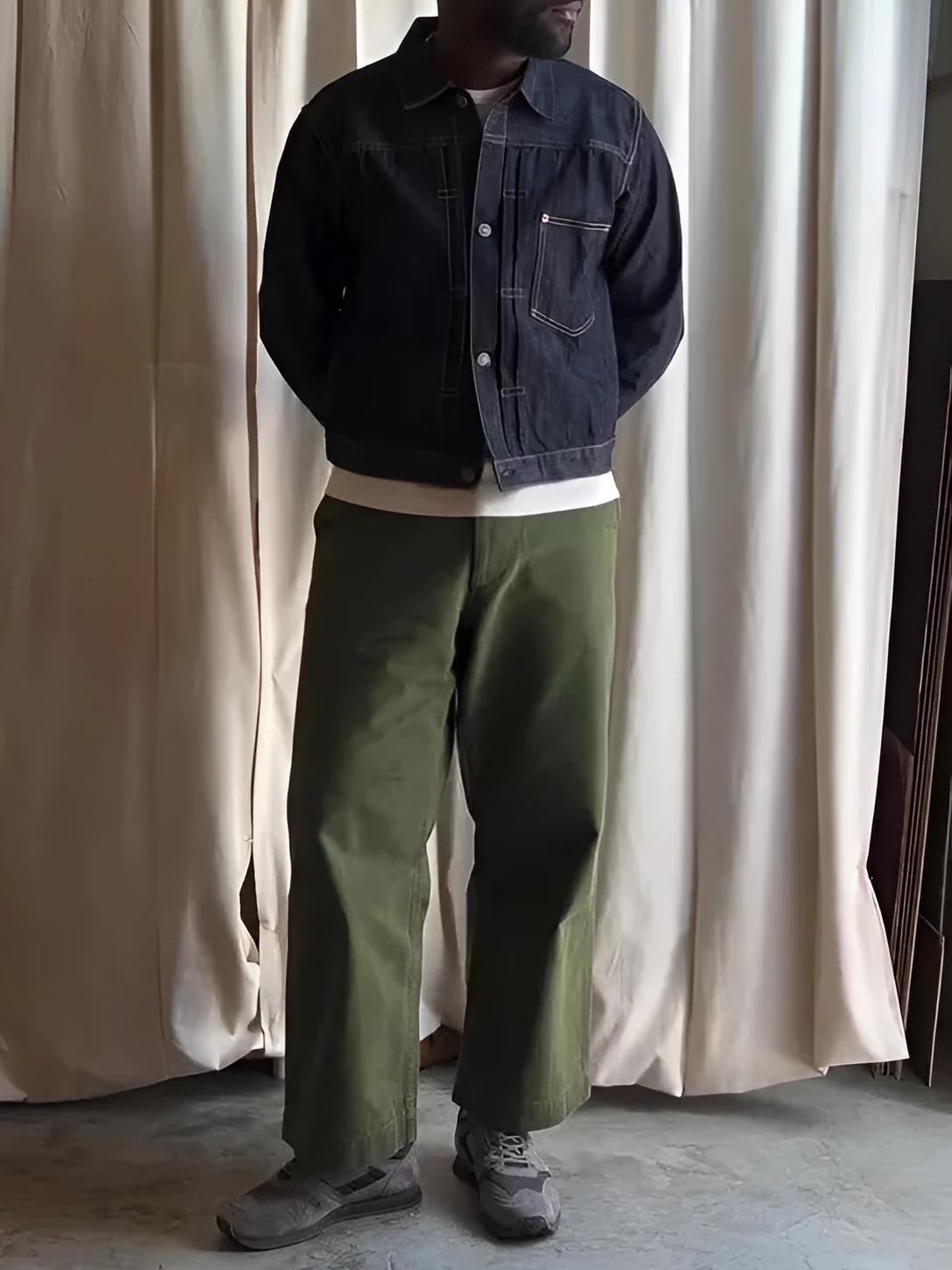 Dark blue denim button-up jacket with classic collar on a standard hanger