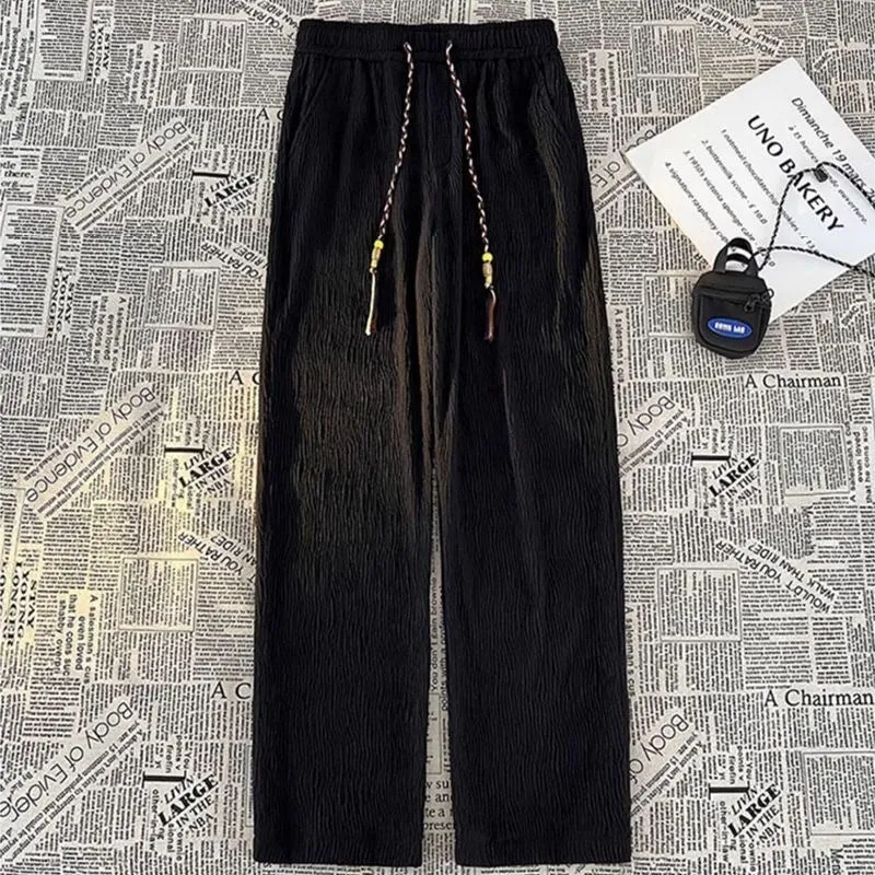 Korean style men's summer pants in black with drooping texture and folding craft detailing