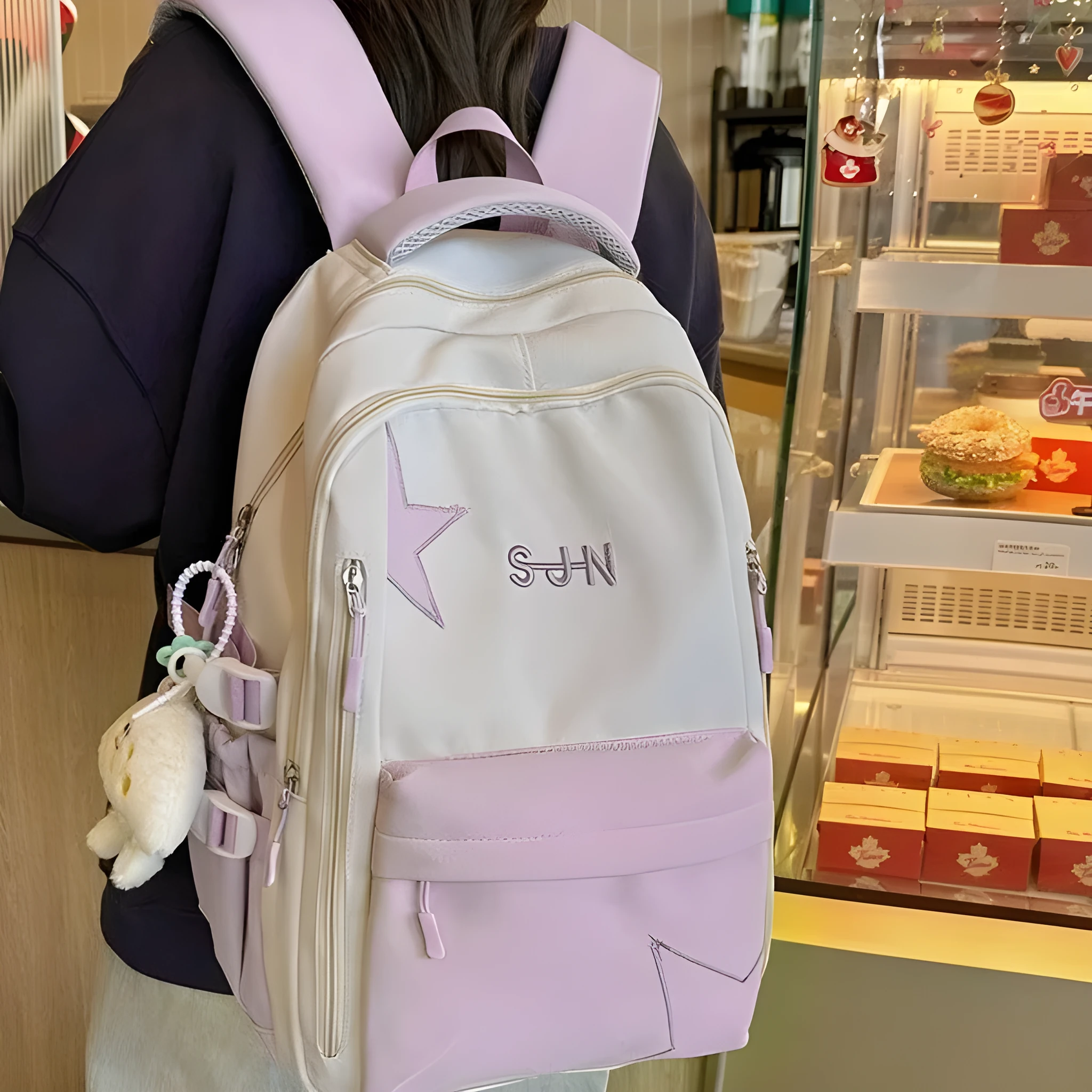 Mori style nylon backpack for women, light blue colour, shown with pendant on a plain background