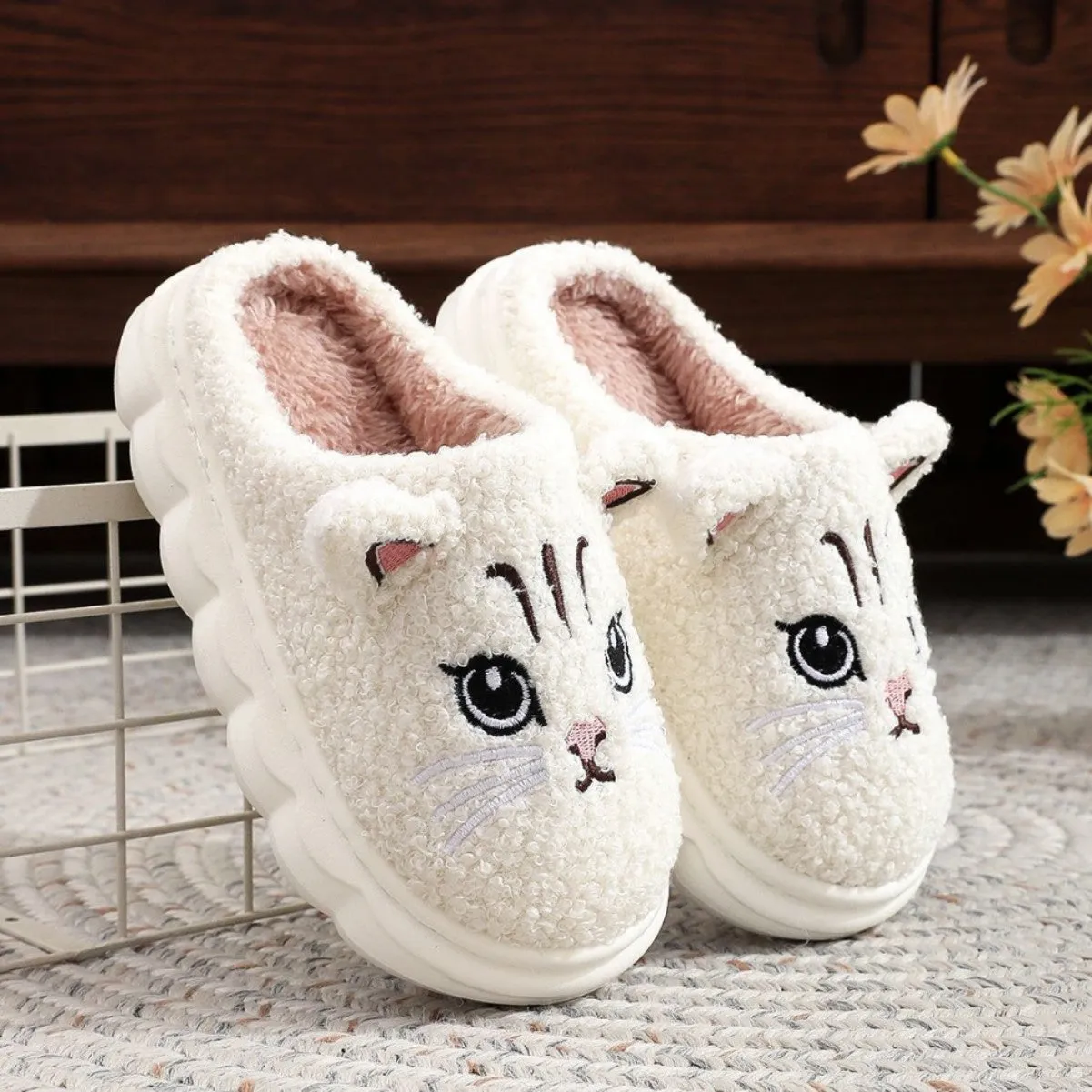 Pair of pink winter cartoon cat fluffy slippers on floor, non-slip EVA sole