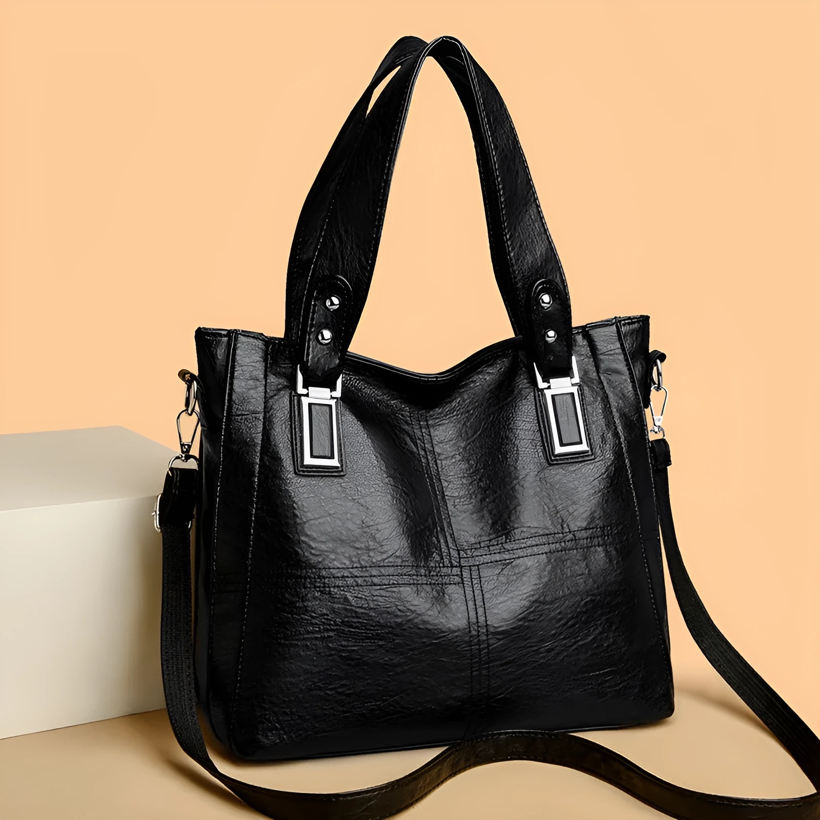 Women's soft PU handbag in horizontal square shape with sewing thread detail and single shoulder strap.