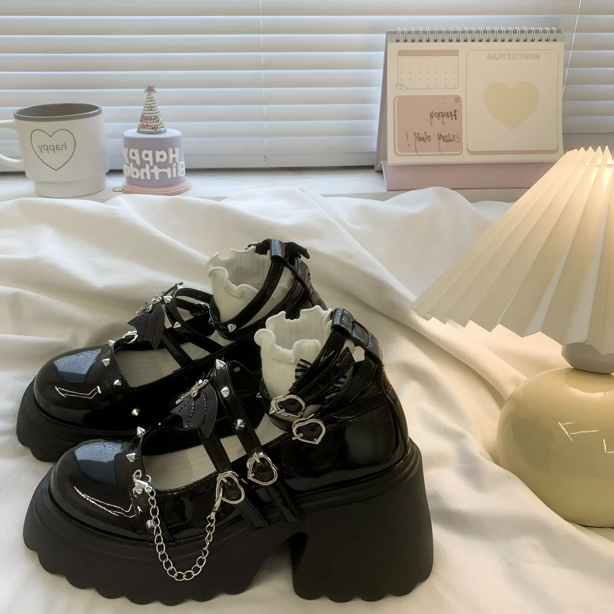Black patent leather bat cosplay Lolita shoes with metal chain buckle and chunky heel on white background