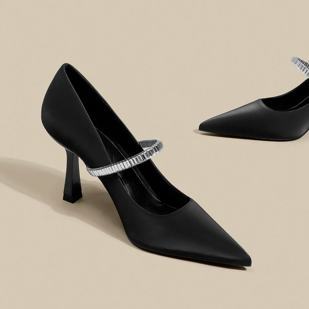 Women's black stiletto heel sandals with a closed toe and a silver buckle strap across the instep.