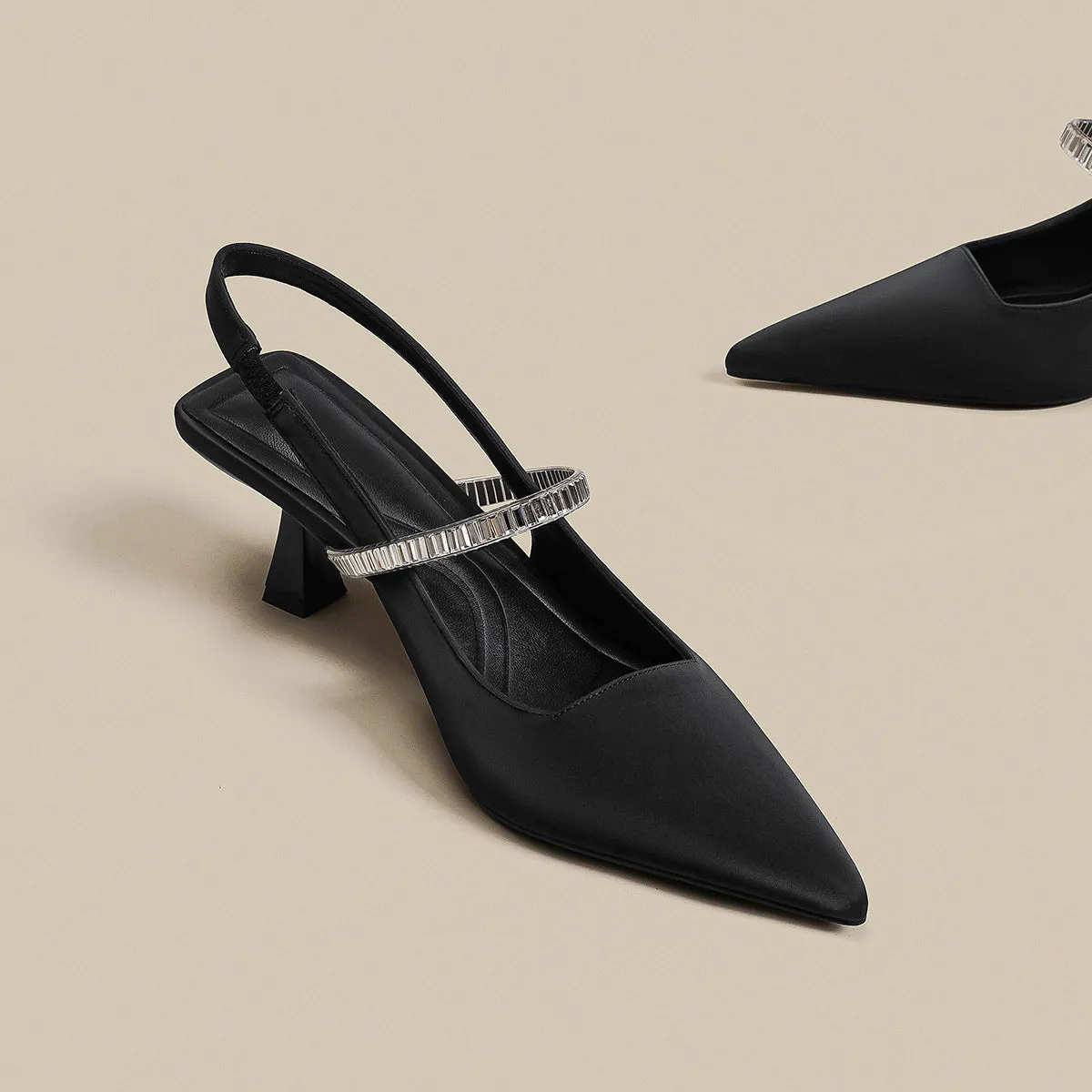 Women's black stiletto heel sandals with a closed toe and a silver buckle strap across the instep.