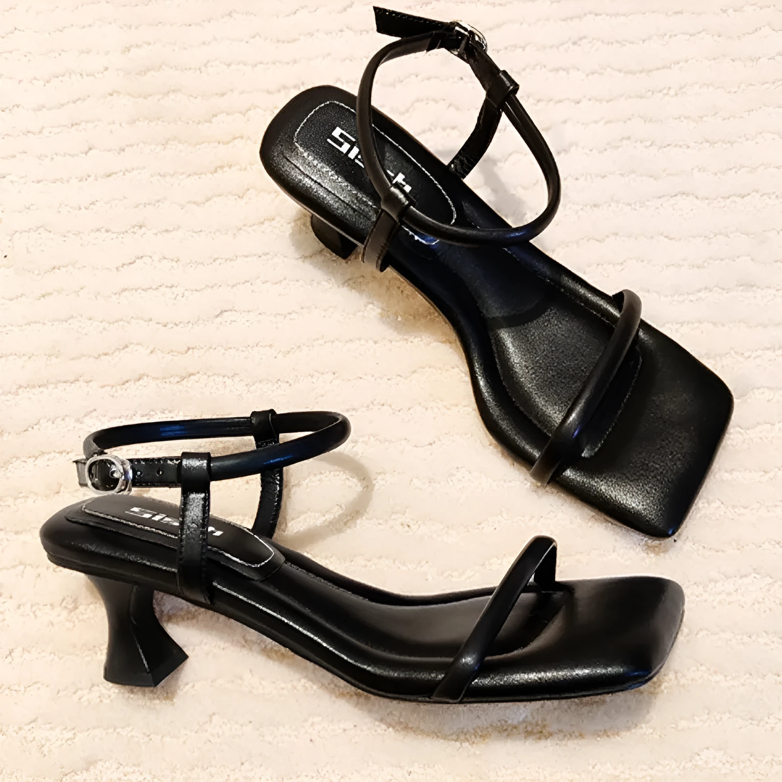 Black women's high heel sandals with a square toe, thick heel, and a single adjustable buckle strap.