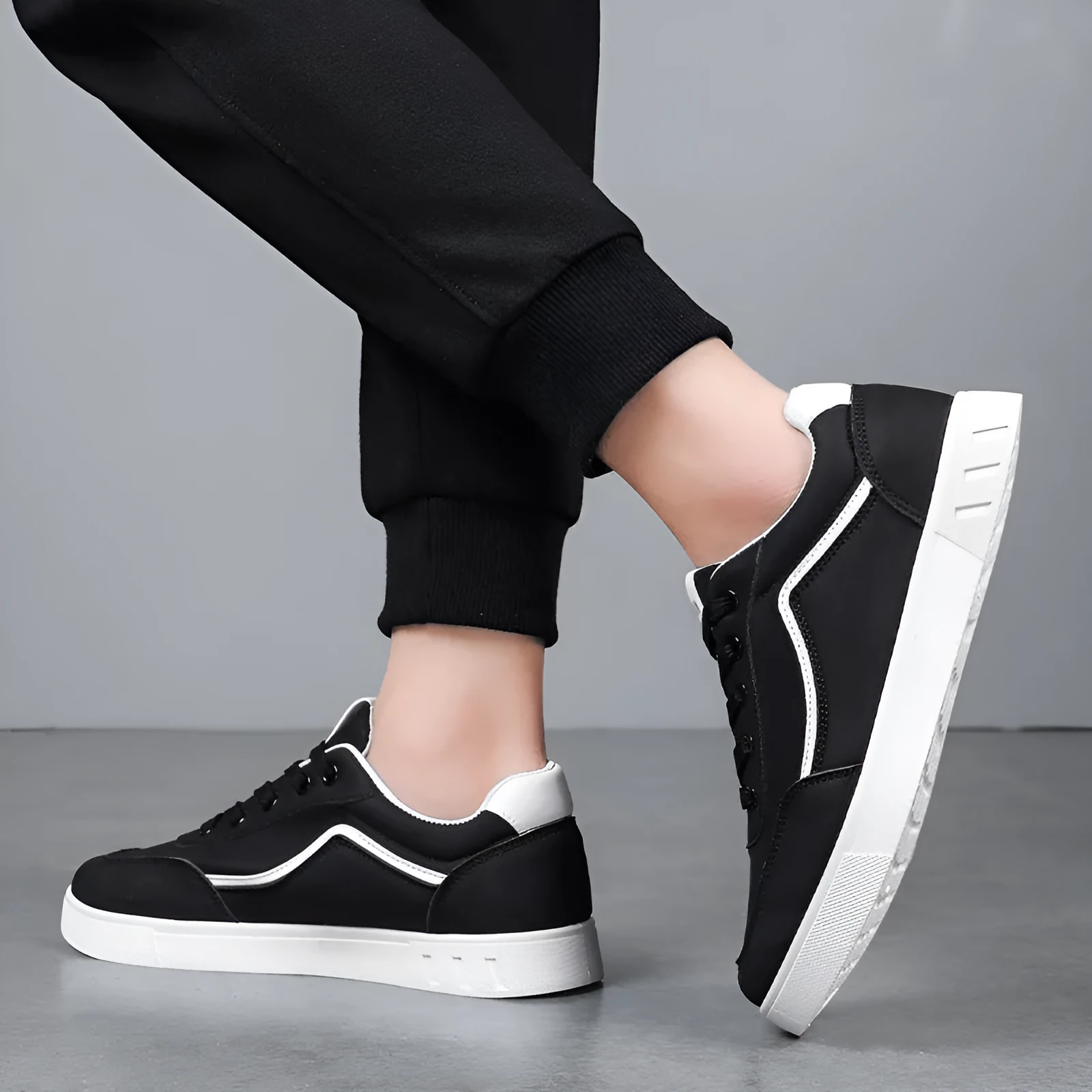 Korean style low top board sneakers in black with white stitching and a flat rubber sole.