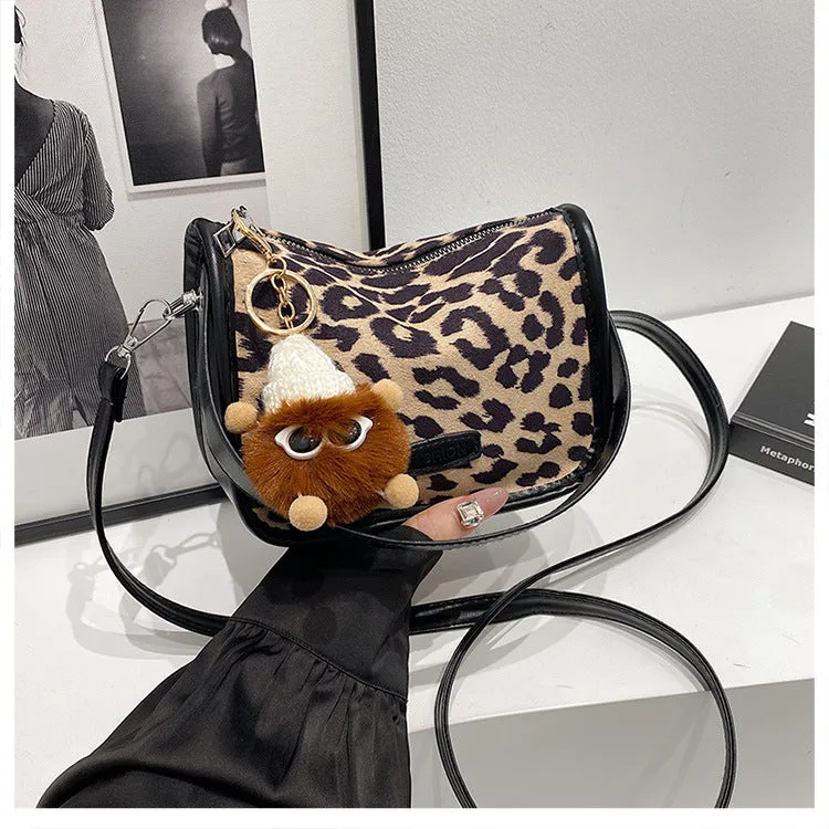High-textured PU messenger bag with leopard print, horizontal square shape, and decorative pendant