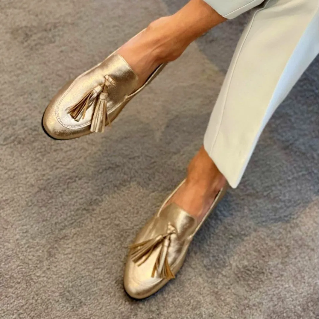 Gold PU leather tassel round toe casual flat loafers with low heel on white background