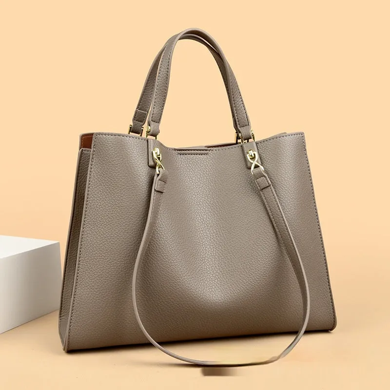 Women's square black PU messenger bag with crossbody strap showing internal organiser pockets.
