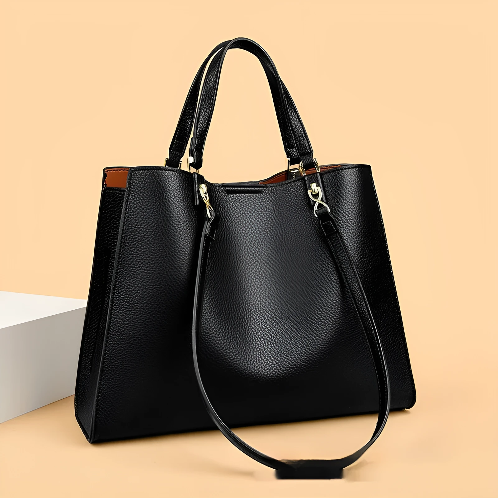 Women's square black PU messenger bag with crossbody strap showing internal organiser pockets.