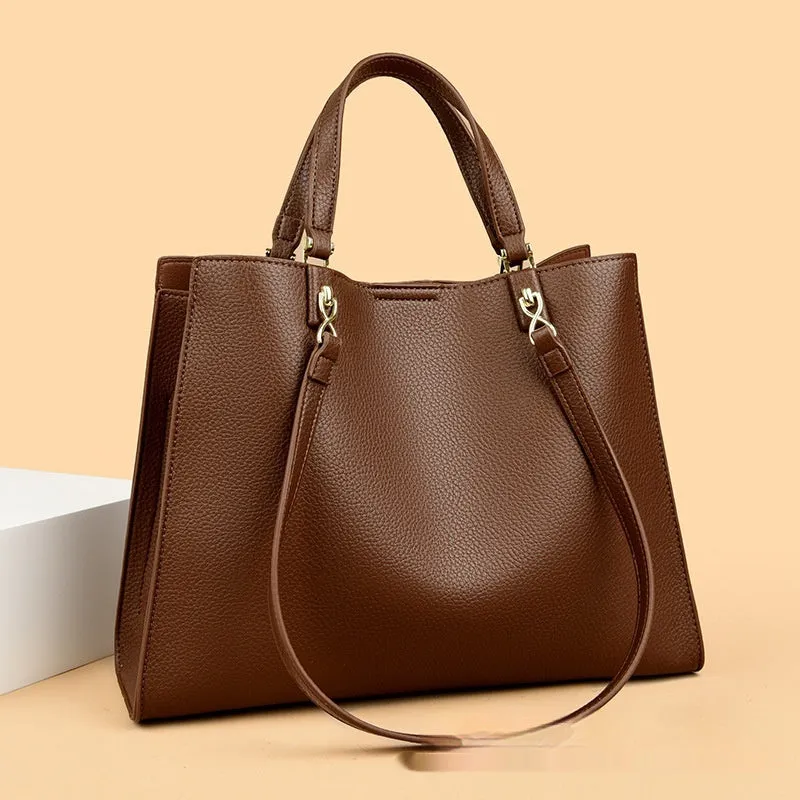 Women's square black PU messenger bag with crossbody strap showing internal organiser pockets.