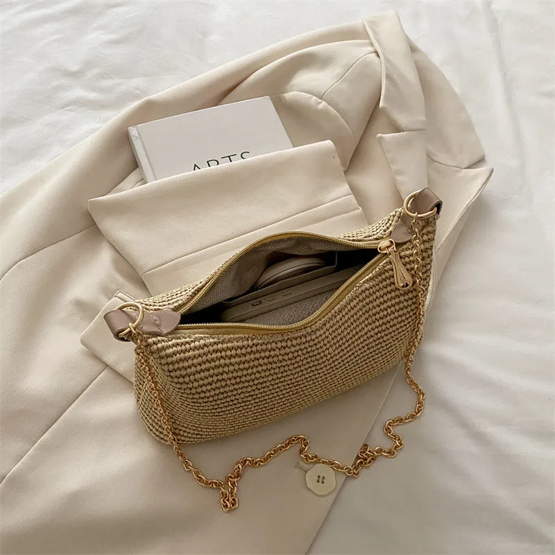 Khaki woven straw crossbody handbag with square shape and crossbody strap.