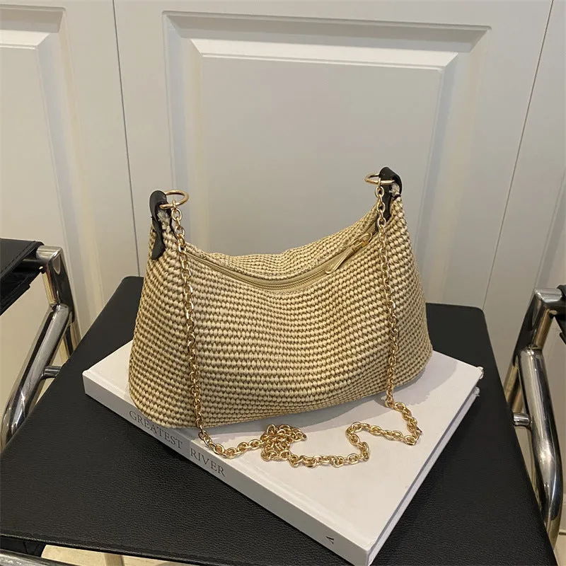 Khaki woven straw crossbody handbag with square shape and crossbody strap.