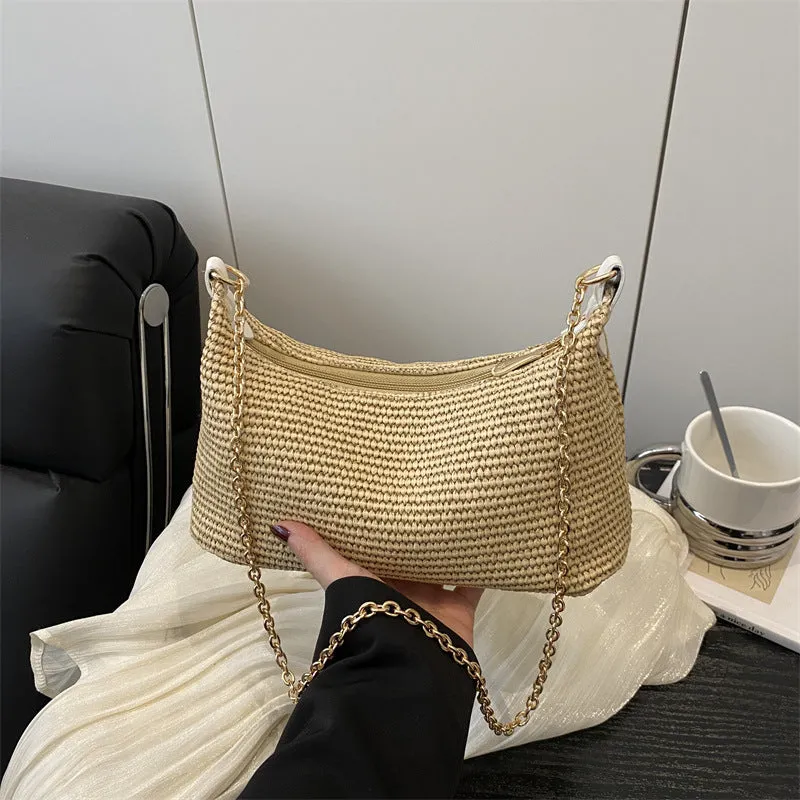 Khaki woven straw crossbody handbag with square shape and crossbody strap.