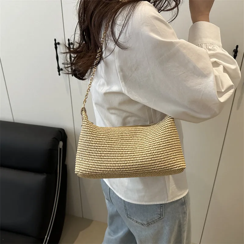 Khaki woven straw crossbody handbag with square shape and crossbody strap.
